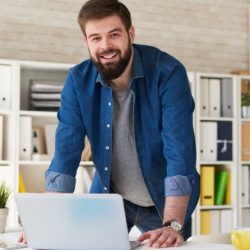 bearded-man-enjoying-work-in-office-CWVFUBT